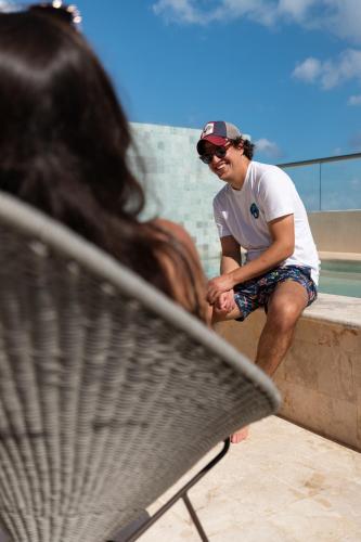 a man sitting on a wall next to a bench at SUUT Hostal Boutique in Playa del Carmen