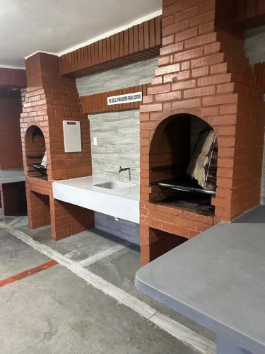 a kitchen with a brick oven with a sink at Apartamento con vista al mar in Tucacas