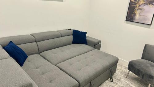 a couch with blue pillows in a living room at Private Very Spacious 2 bed 1-Bedroom basement Suite SW Calgary in Calgary