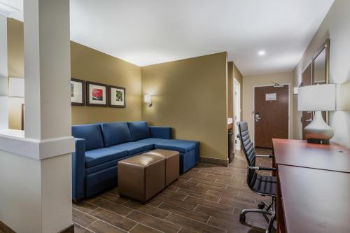 a living room with a blue couch in a room at Comfort Suites Bowling Green Southeast in Bowling Green