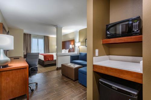 a small hotel room with a room with a bed and a microwave at Comfort Suites Bowling Green Southeast in Bowling Green