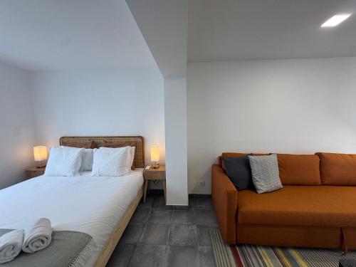 a bedroom with a bed and a couch at Estoril Nest- Walk to the Beach in Estoril