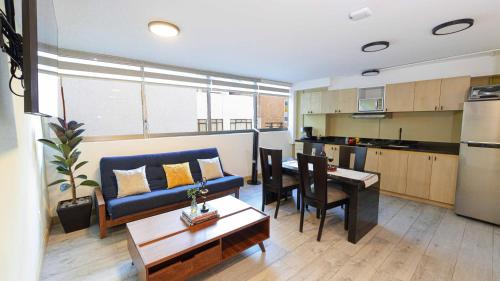a living room with a couch and a table and a kitchen at Homero 538: Apartamentos Equipados en Polanco in Mexico City