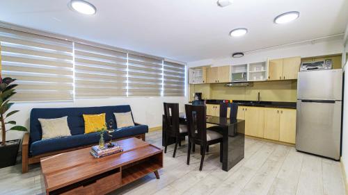 a living room with a blue couch and a kitchen at Homero 538: Apartamentos Equipados en Polanco in Mexico City