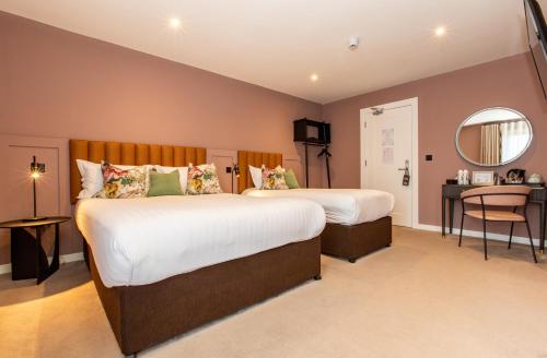 a hotel room with two beds and a mirror at Silken Thomas Accommodation in Kildare