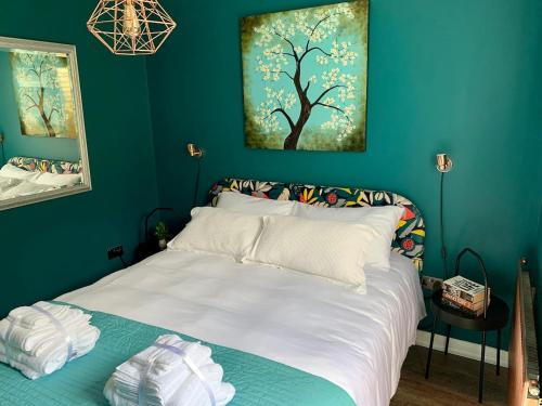 a bedroom with a white bed with a blue wall at Modern with parking near Windsor Castle & Legoland in Windsor