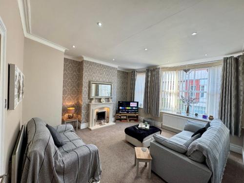 a living room with a couch and a fireplace at Park View Maisonette, Luxurious 3 bed holiday home in Whitley Bay