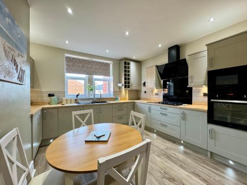 a kitchen with a wooden table and a dining room at Park View Maisonette, Luxurious 3 bed holiday home in Whitley Bay