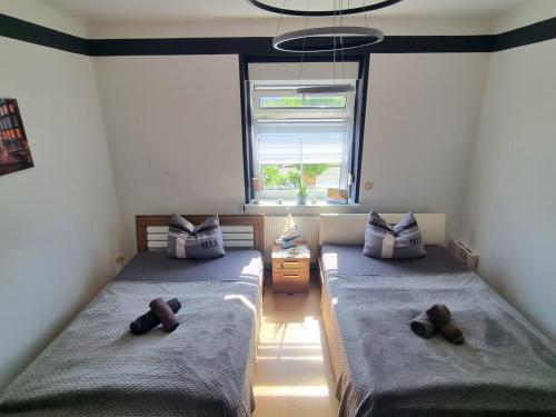 a bedroom with two beds and a window at Ferienwohnung *Zur Weinbergstraße* in Lauta
