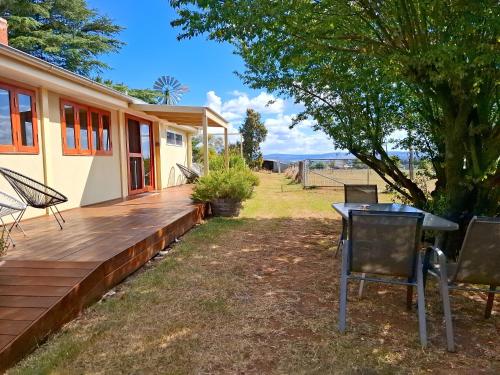 a patio with a table and chairs on a deck at Alloway Bank in Bathurst