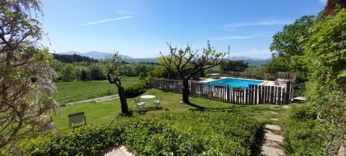 une cour arrière avec piscine et arbres dans l'établissement Le Jas des Sagnières - Gite de Charme en Haute Provence -, à Sigoyer