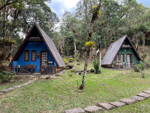 a small blue house with a thatch roof at A Luz Azul - Pousada e Gastronomia in Bananal