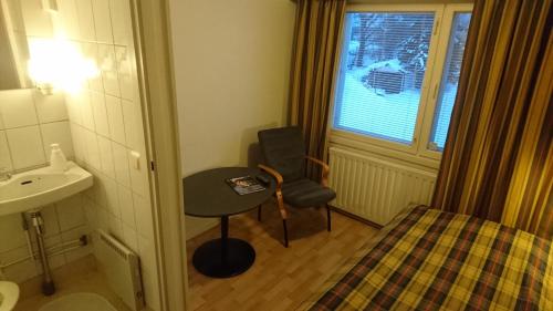 a small bathroom with a sink and a chair at Guesthouse Golden Goose in Kittilä