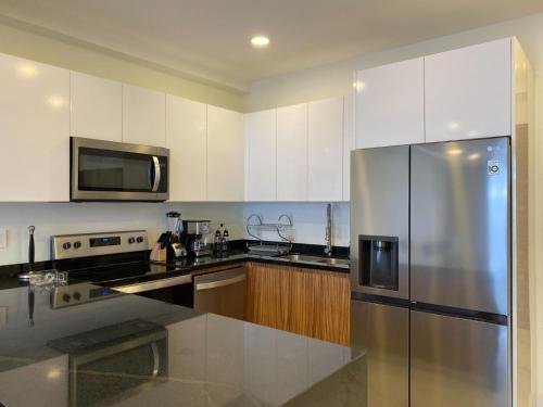a kitchen with a stainless steel refrigerator and a microwave at Quinta San Miguel con Alberca, Playa a 5 minutos. in Bucerías