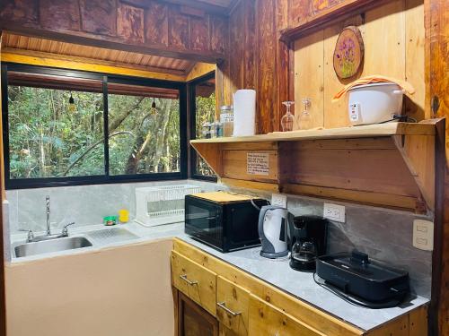 a kitchen with a microwave and a sink at Cabañas La Montaña in Monteverde Costa Rica