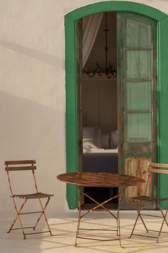 a table and a chair in a room with a bed at Hotel Emblemático La Casa de los Naranjos in Haría