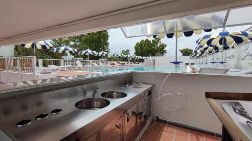 a kitchen with a sink and a swimming pool at Residence La Bricola Sestante 26 in I Casoni