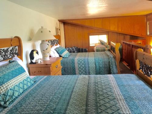 a bedroom with two beds and a table with a lamp at Knott Lakeview in Bass Lake