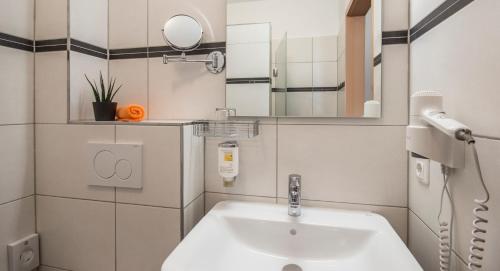 bagno con lavandino e specchio di GS Hotel a Monaco