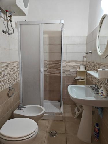 a bathroom with a shower and a toilet and a sink at Casa in Piazza in Fondi