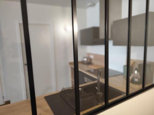 Cette chambre dispose d'une fenêtre en verre avec un lavabo. dans l'établissement Le Refuge des Tanneurs, à Romans-sur-Isère