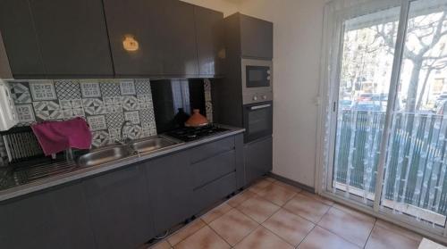 d'une cuisine équipée d'appareils en acier inoxydable et d'une grande fenêtre. dans l'établissement Fati66, à Perpignan