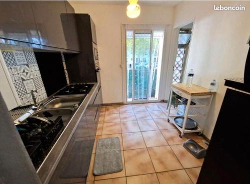 une cuisine avec un évier et une cuisinière four supérieur dans l'établissement Fati66, à Perpignan