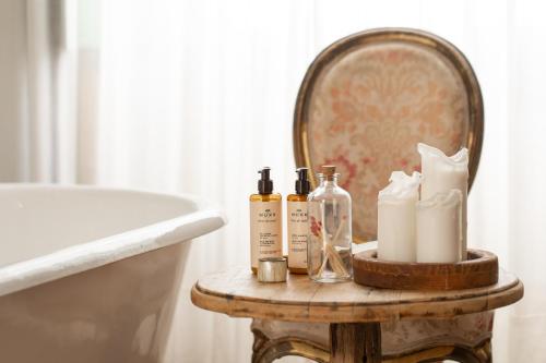 a table with bottles and towels on a table next to a tub at Hotel Emblemático La Casa de los Naranjos in Haría