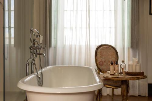a white bath tub in a bathroom with a window at Hotel Emblemático La Casa de los Naranjos in Haría