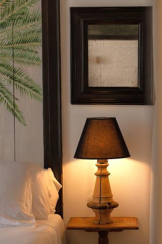 a lamp sitting on a table next to a bed at Hotel Emblemático La Casa de los Naranjos in Haría