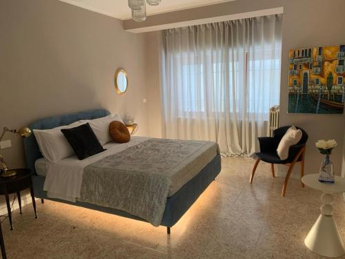a bedroom with a bed and a chair and a window at Casa Virgilio in Venosa