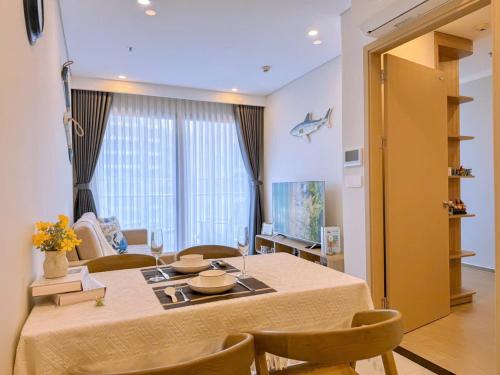 a room with a table with chairs and a living room at A cozy condotel in Bai Sau(1 bed and 1 sofa bed) in Vung Tau