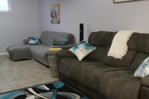 a living room with a brown couch and a couches at Calgary's Home Cinema Retreat in Calgary