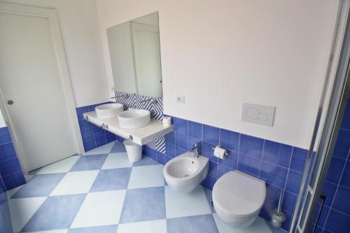 a blue and white bathroom with a toilet and a sink at Maison Tonina Sorrento Coast in Sant'Agnello