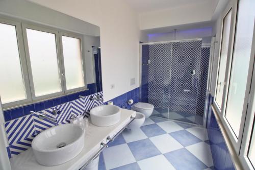 a blue and white bathroom with two sinks and a shower at Maison Tonina Sorrento Coast in Sant'Agnello