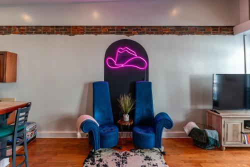 a living room with two blue chairs and a tv at Jolene's Hideout - Noise Notice Wed-Sun in Knoxville