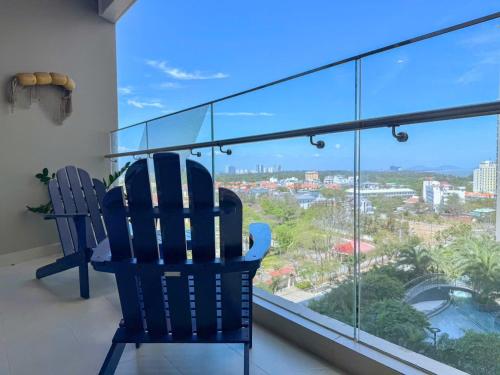 a balcony with two chairs and a large window at A cozy condotel in Bai Sau(1 bed and 1 sofa bed) in Vung Tau
