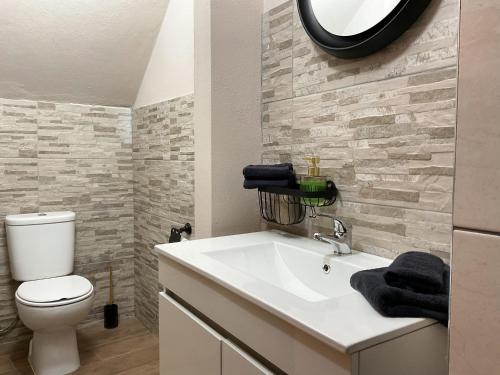 a bathroom with a white sink and a toilet at Casa Pinheiro in Pinheiro de Coja