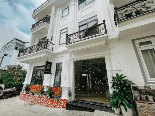 a white building with balconies on a street at Oriana Dalat in Da Lat