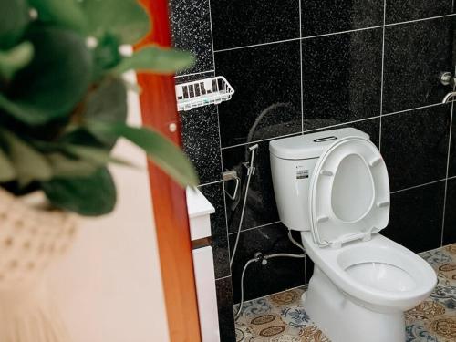 a bathroom with a white toilet and a plant at Oriana Dalat in Da Lat