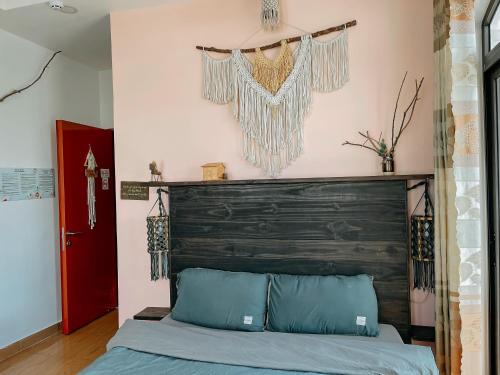 a bedroom with a bed with a wooden headboard at Oriana Dalat in Da Lat