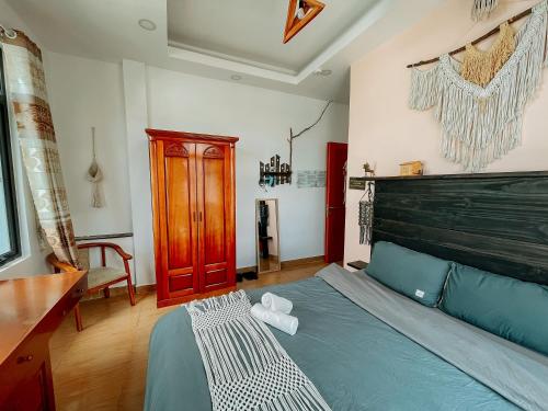 a bedroom with a bed with a wooden headboard at Oriana Dalat in Da Lat