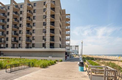 a building on a beach with a boardwalk next to the beach at Virginia one #515 in Rehoboth Beach