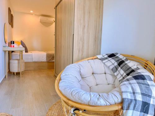 a room with a chair and a bedroom with a bed at A cozy condotel in Bai Sau(1 bed and 1 sofa bed) in Vung Tau