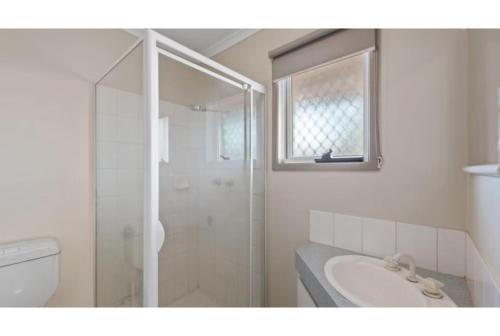 a white bathroom with a shower and a sink at Discovery Parks - Port Hedland in Port Hedland