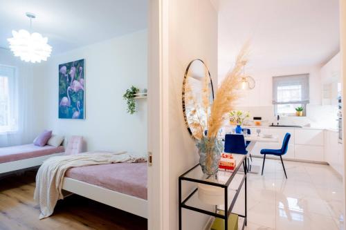a bedroom with a bed and a table with a mirror at White Rose Hill Luxury Apartment Budapest in Budapest