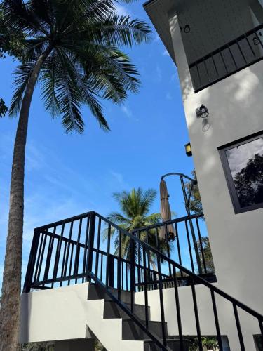 a staircase leading up to a house with a palm tree at Tanouy Garden in Baan Khai