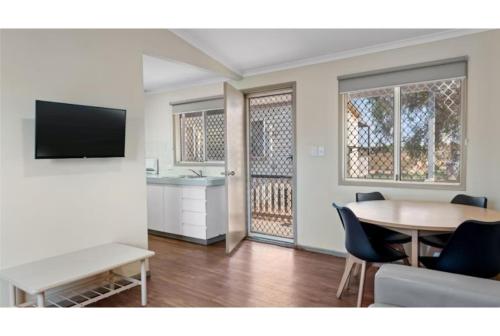 a living room with a table and a kitchen at Discovery Parks - Port Hedland in Port Hedland