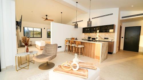 a kitchen and living room with a table and chairs at Sirena Bay Beach House and Luxury Suites in Protaras