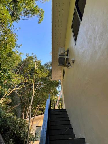 a staircase leading up to a building with trees at Tanouy Garden in Baan Khai